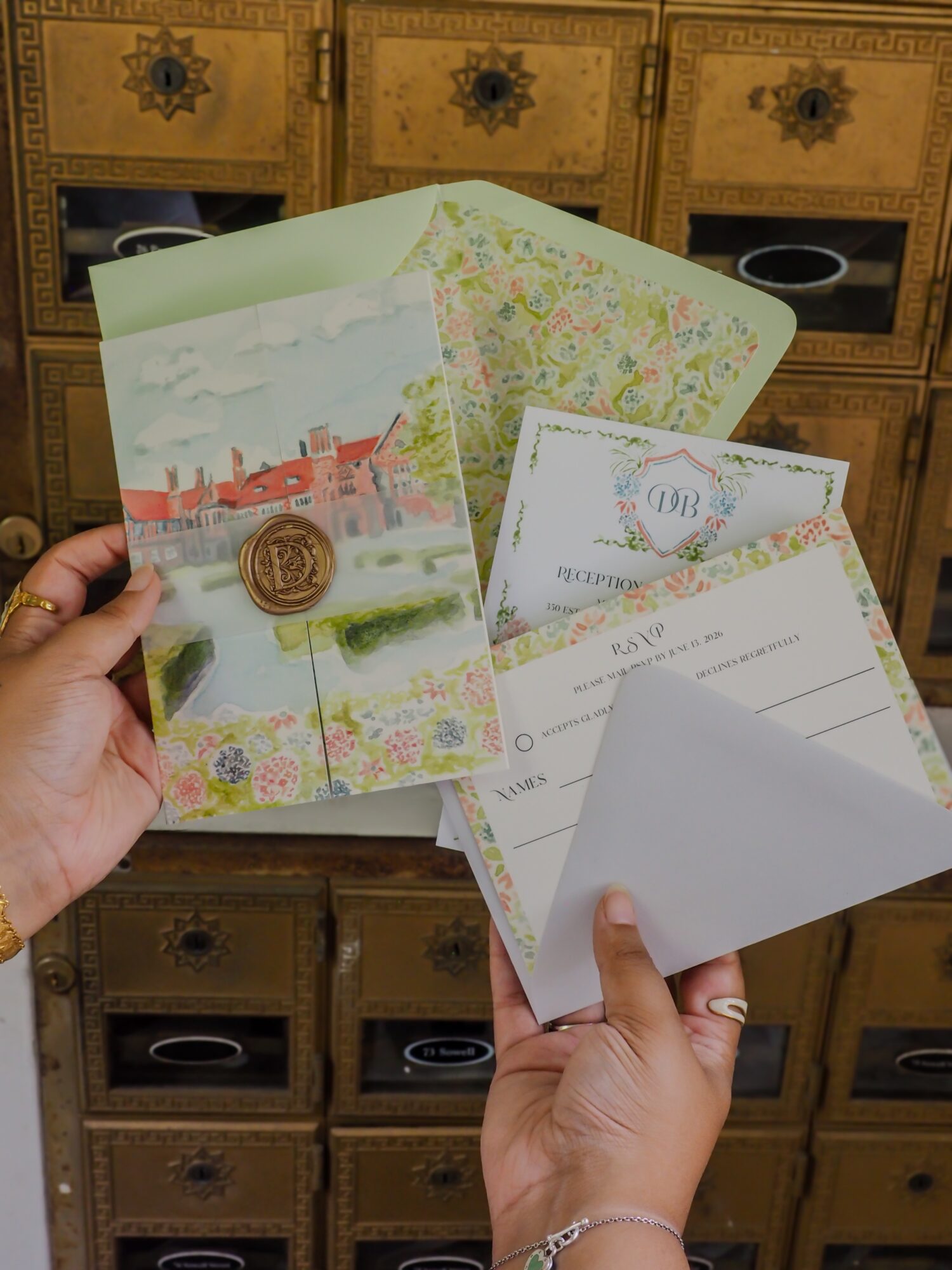 Person holding colorful postcards and envelopes, background of wooden drawers with decorative handles.