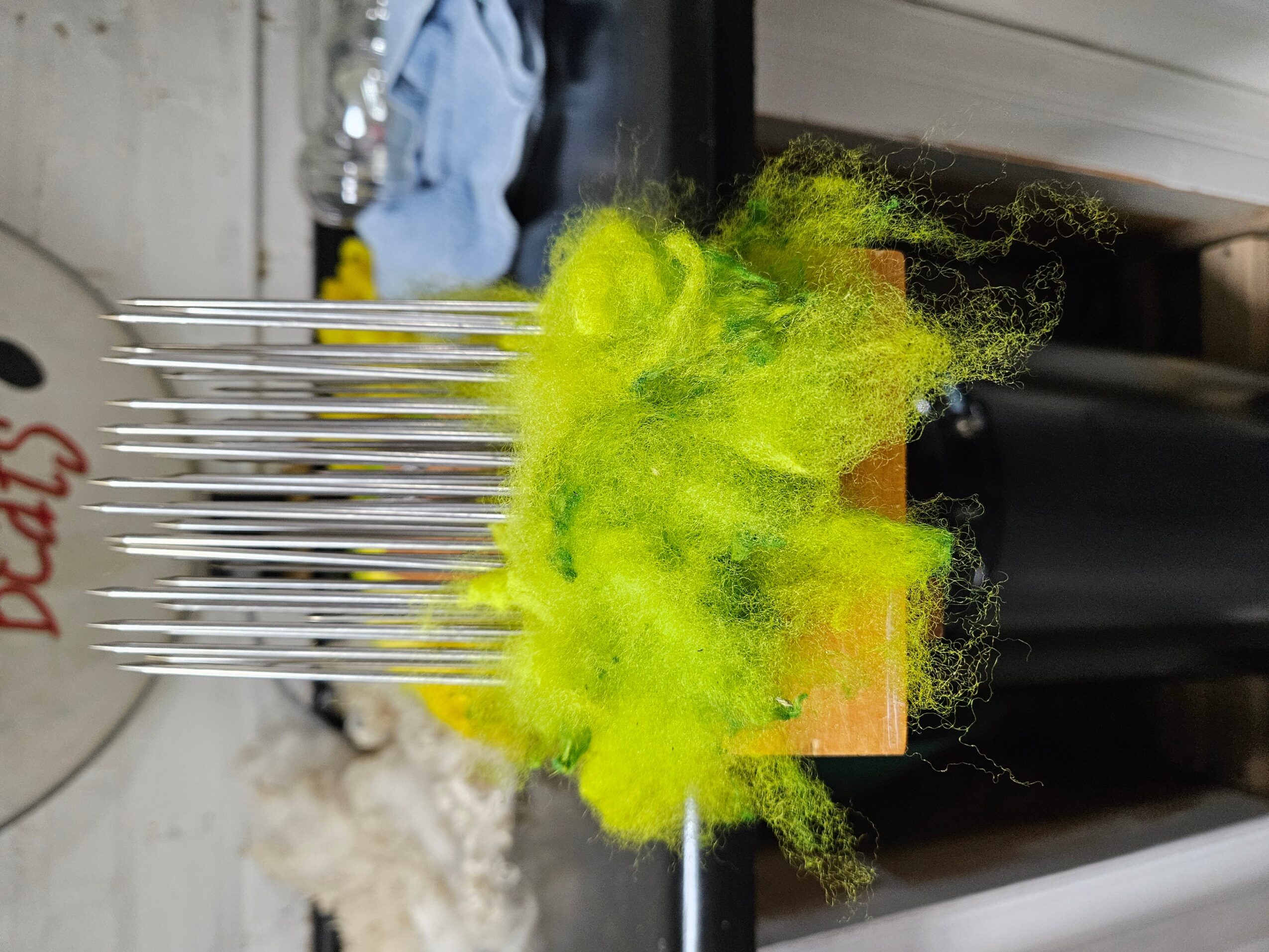 Bright yellow-green smoke or vapor emerging from a black cylindrical object, with a blurred background.