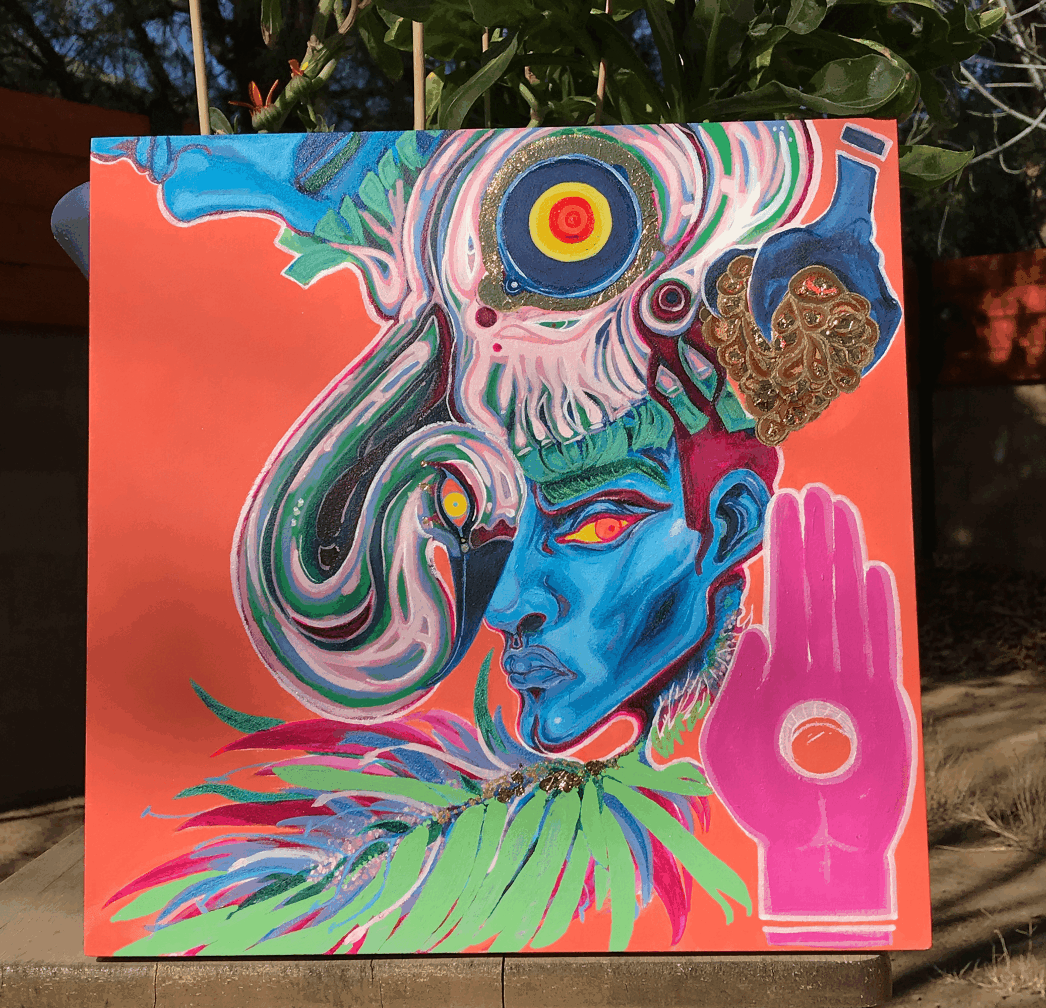 Colorful abstract painting of a blue face with swirling patterns, a pink hand, and vibrant background elements.