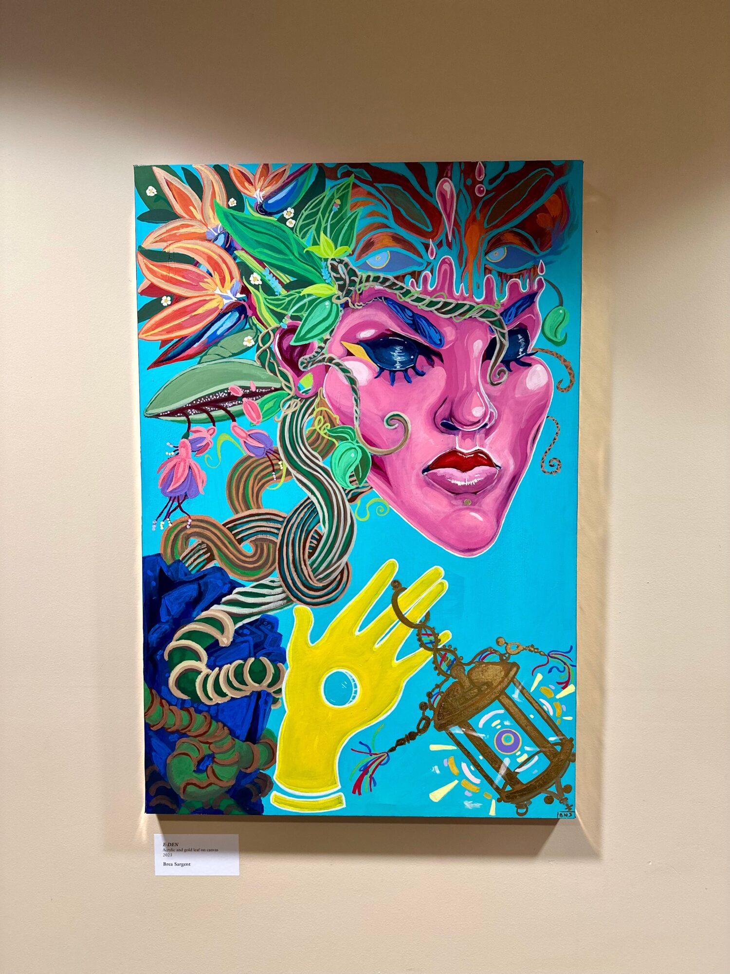 Colorful painting of a woman's face with vibrant hair, a yellow hand holding a spray can, and abstract background elements.
