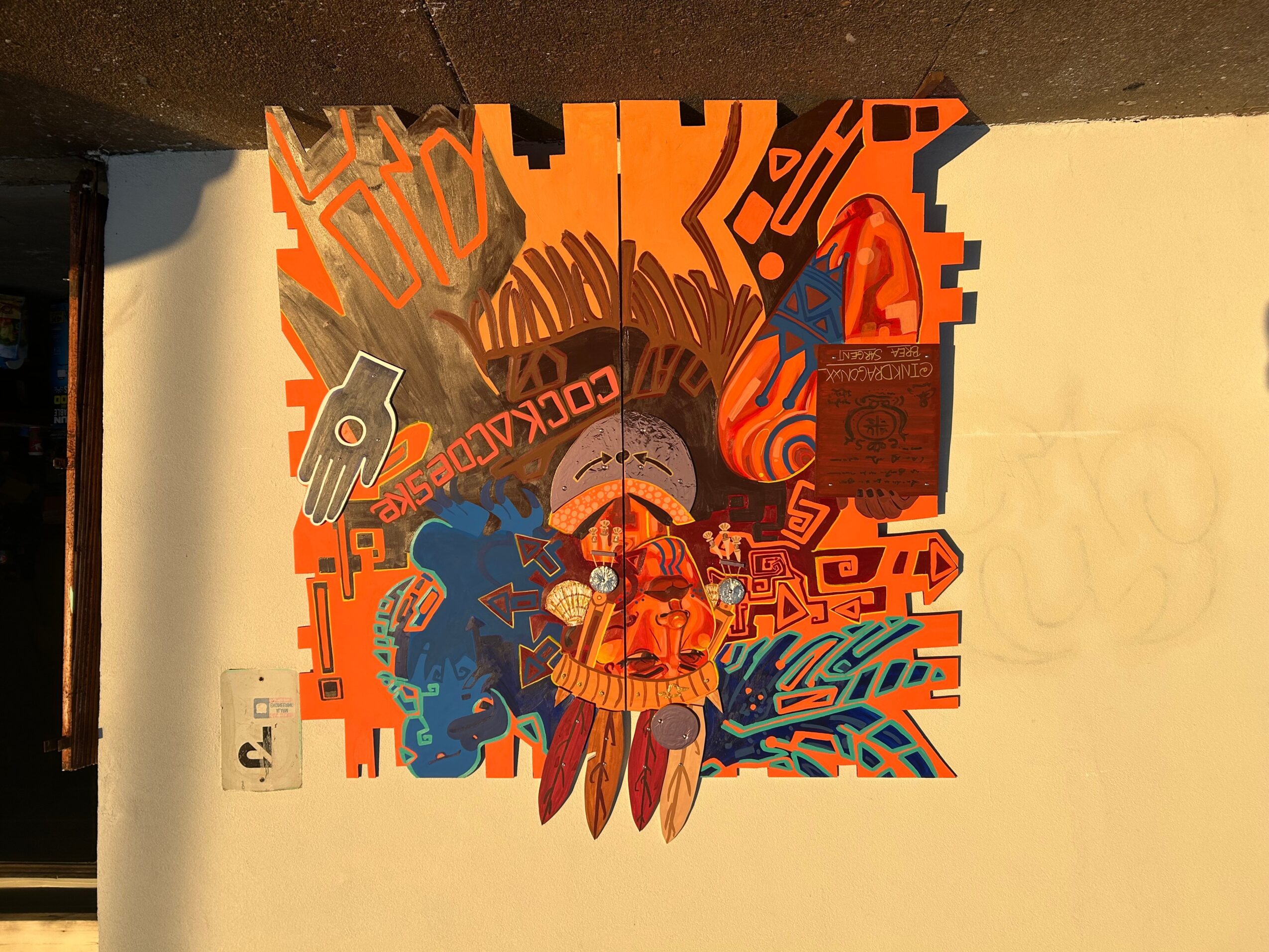Colorful graffiti art with abstract shapes, a person in the center, and various patterns in orange, blue, and gray.