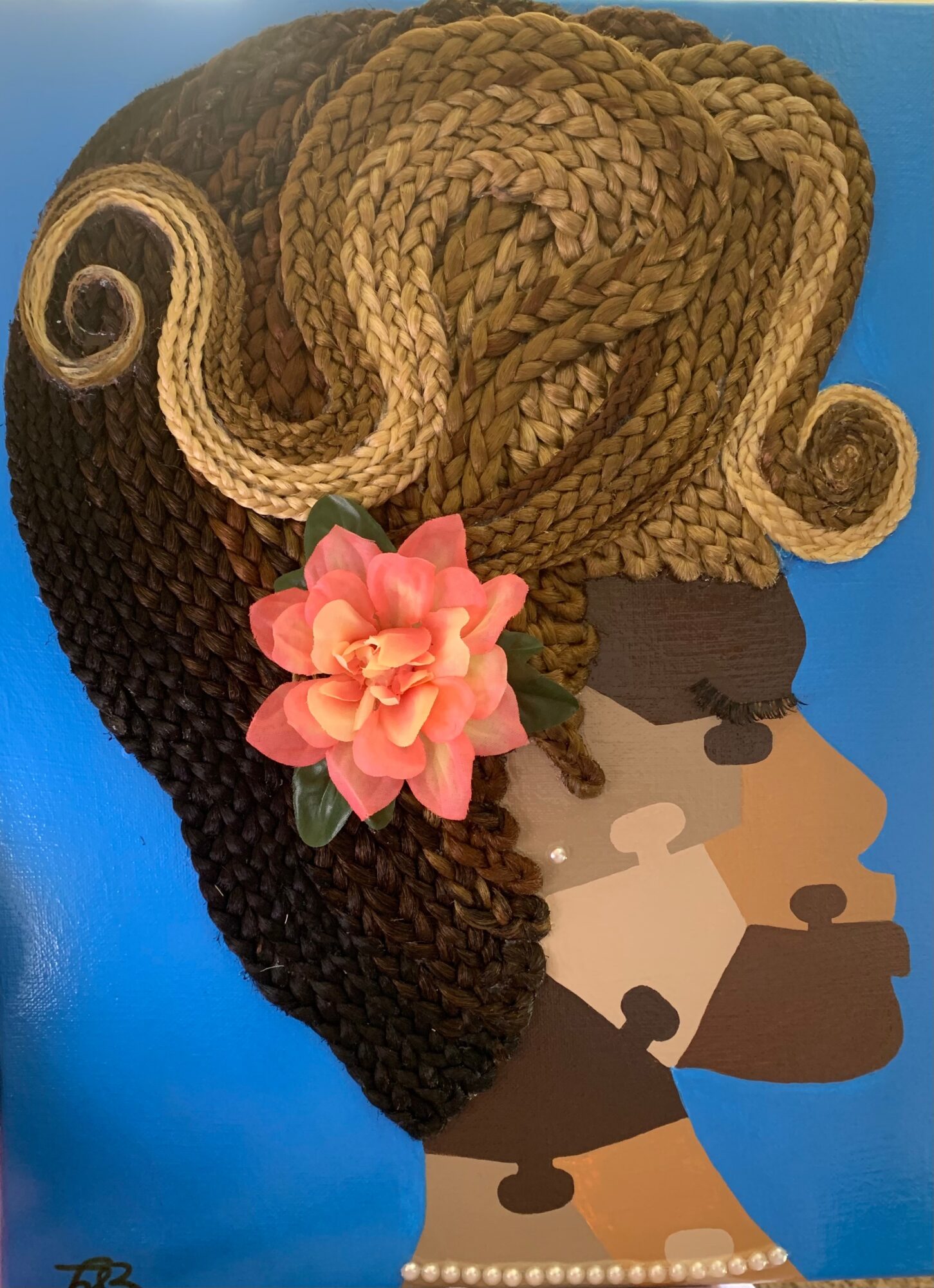 Profile of a woman with braided hair, a pink flower in her hair, and a blue background.