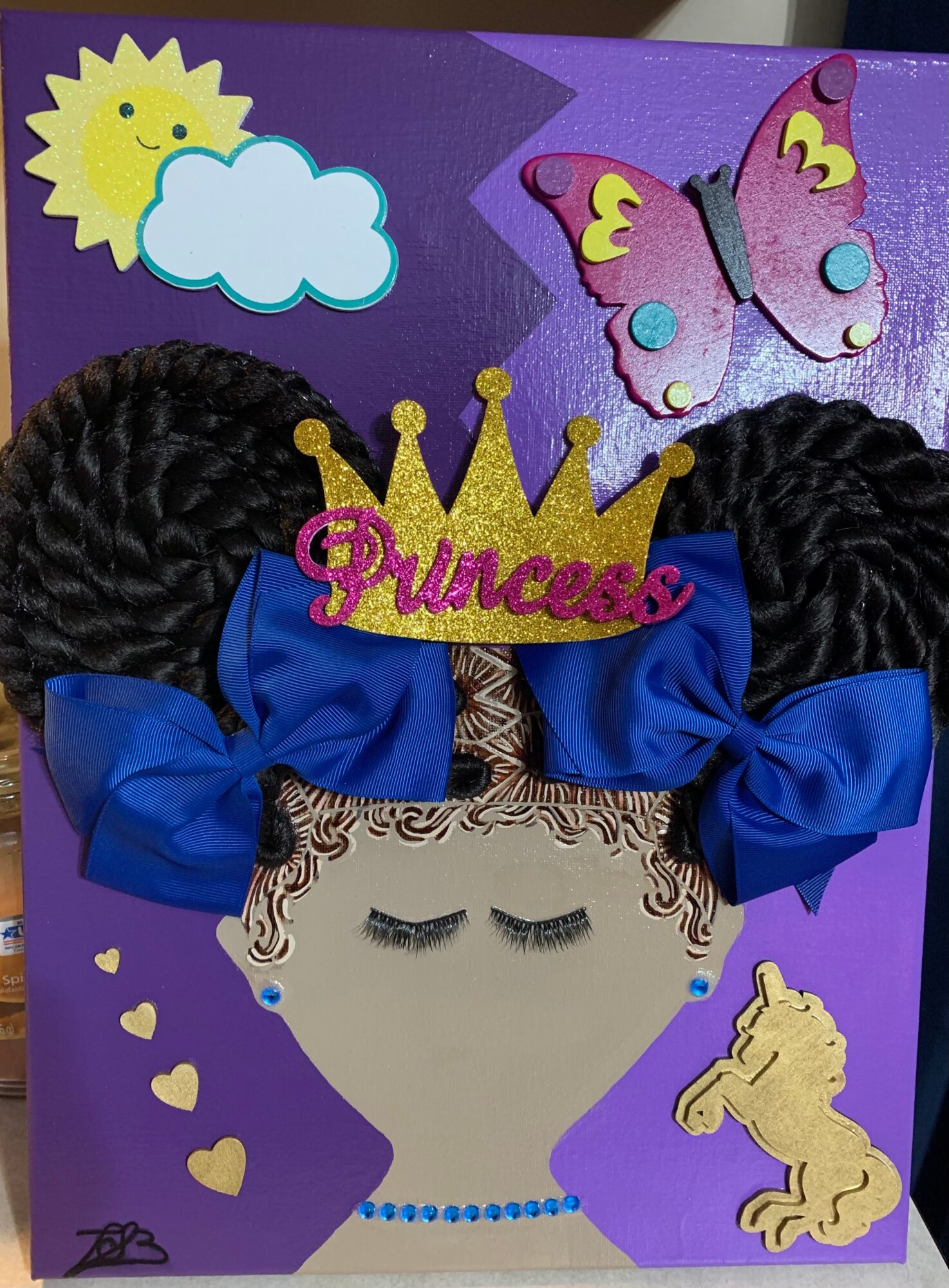 Decorative princess-themed card with a crown, butterfly, cloud, and horse, featuring a girl's face with braided hair and blue bows.
