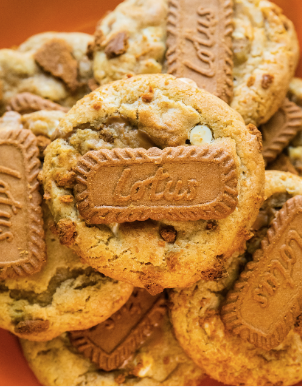 Golden cookies topped with rectangular embossed biscuits, piled together.